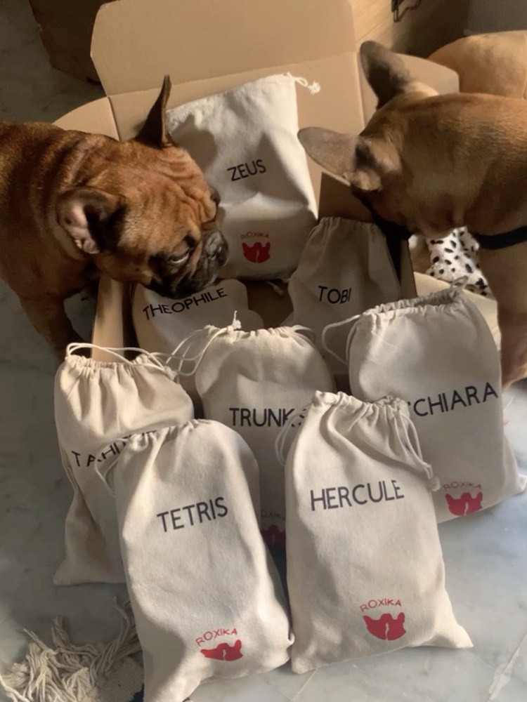 Paprika et Roxa reniflent une fournée de pochons en coton brodés aux prénoms de leurs destinataires&nbsp;: Théophile, Zeus, Tobi, Tetris, Hercule, Chiara