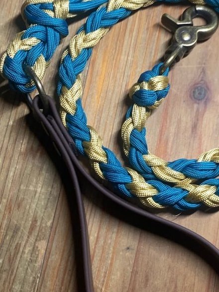 La tresse à quatre brins d'une laisse, en paracorde teal et or